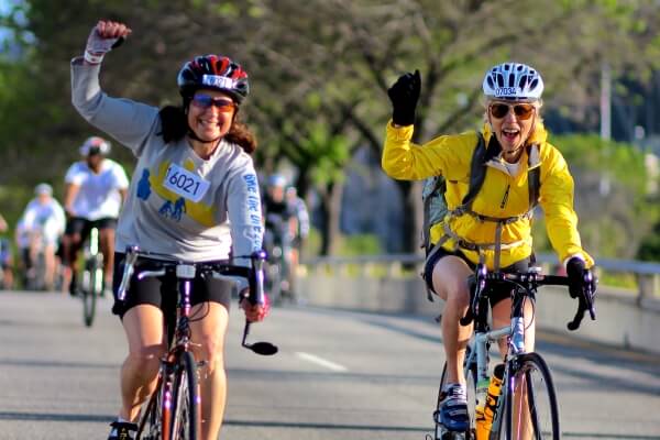 smiling women riding bikes